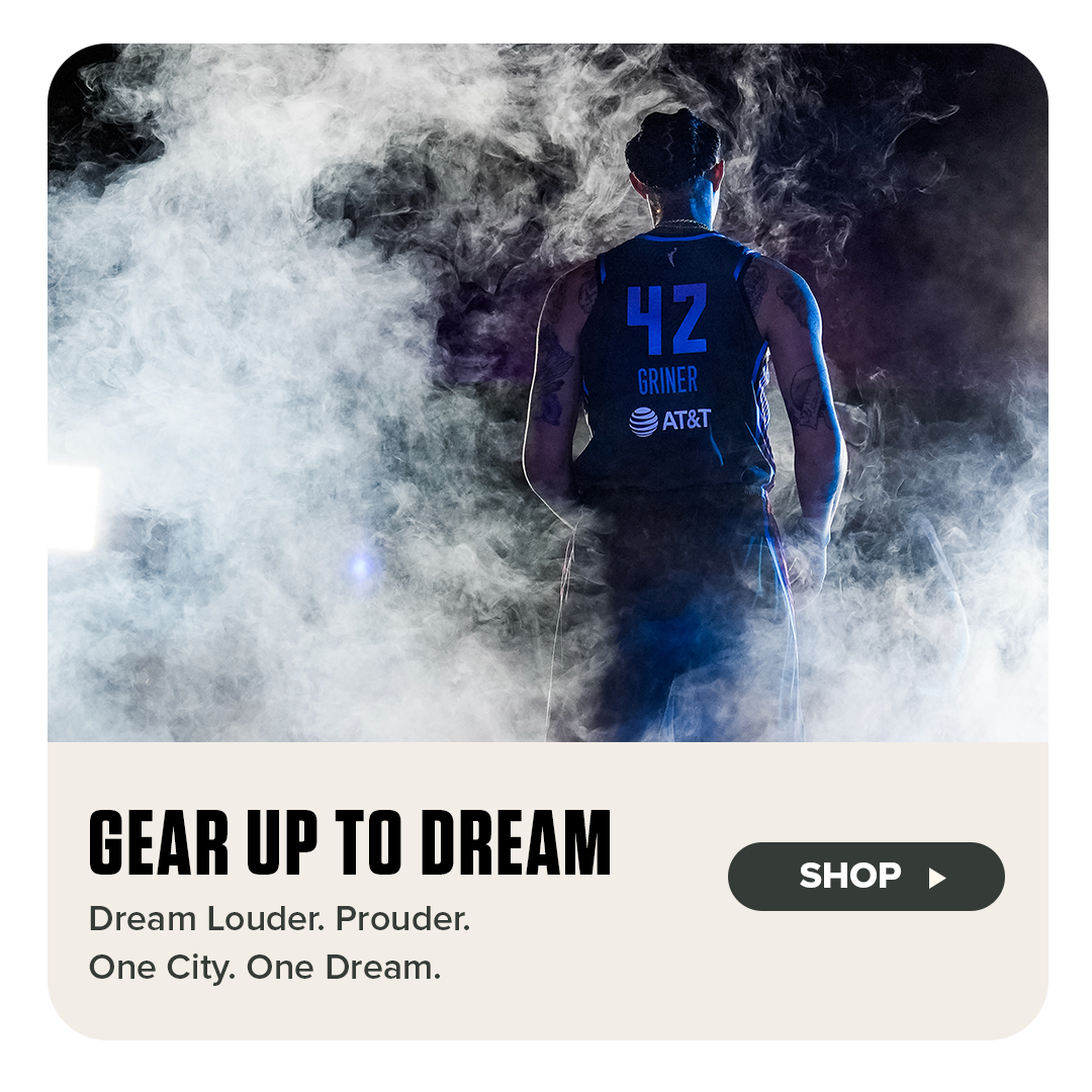 A powerful image of WNBA player Brittney Griner, seen from behind wearing a dark Atlanta Dream jersey with the number 42, stands in a cloud of dramatic smoke and spotlight. Below, bold text reads “Gear Up to Dream” with the tagline “Dream Louder. Prouder. One City. One Dream.” A “Shop” button invites fans to explore the collection.







