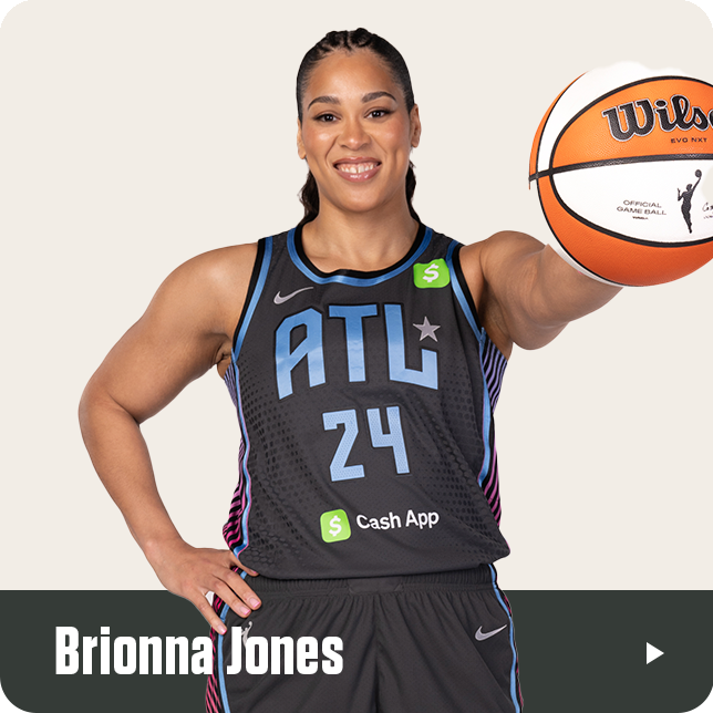 Brionna Jones, wearing the black Atlanta Dream jersey with the number 24 and Cash App sponsor logo, smiles confidently while extending a WNBA Wilson basketball toward the camera. Her name is displayed in bold white text at the bottom of the image.







