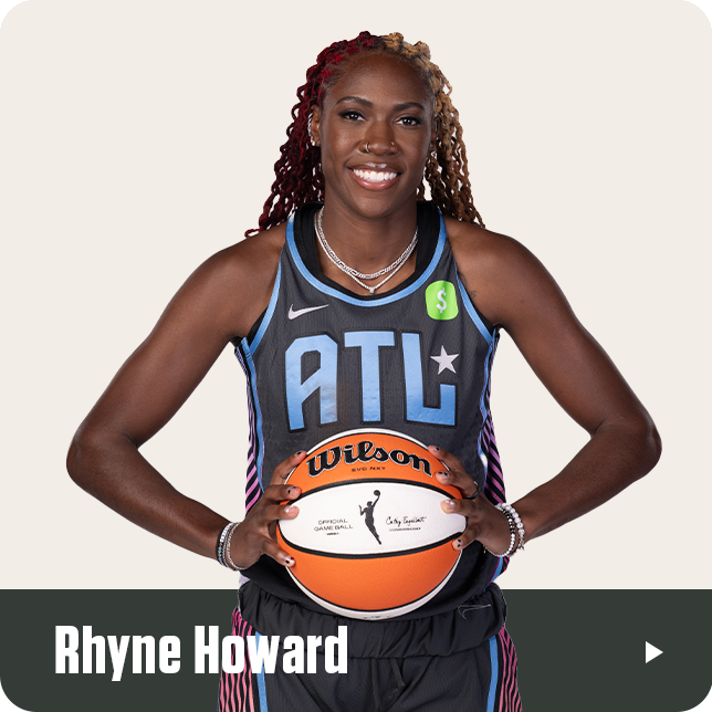 Rhyne Howard, wearing the black Atlanta Dream jersey with the ATL logo and Cash App sponsor patch, smiles while holding a WNBA Wilson basketball in front of her waist. Her long, multi-toned braids and confident stance highlight her presence. Her name is displayed in bold white text at the bottom of the image.